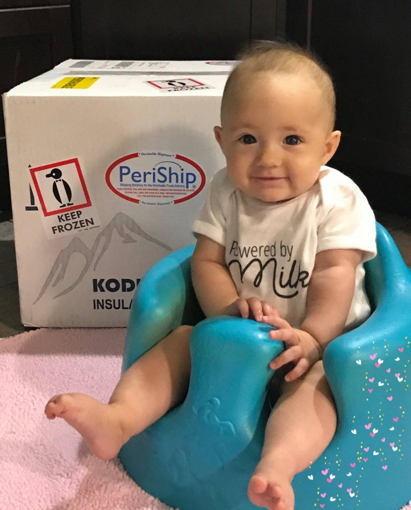 Baby with box of donated milk