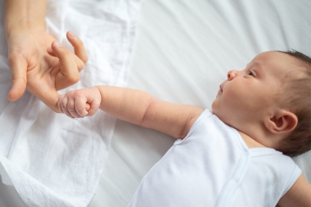 newborn baby grips mothers' finger