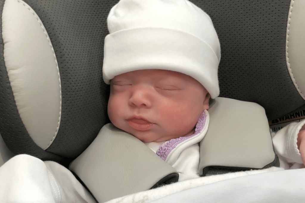 A baby girl sleeping soundly in her car set 