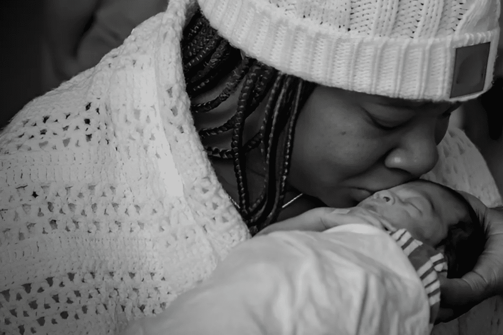 Baby Miracle receives a kiss from Mom