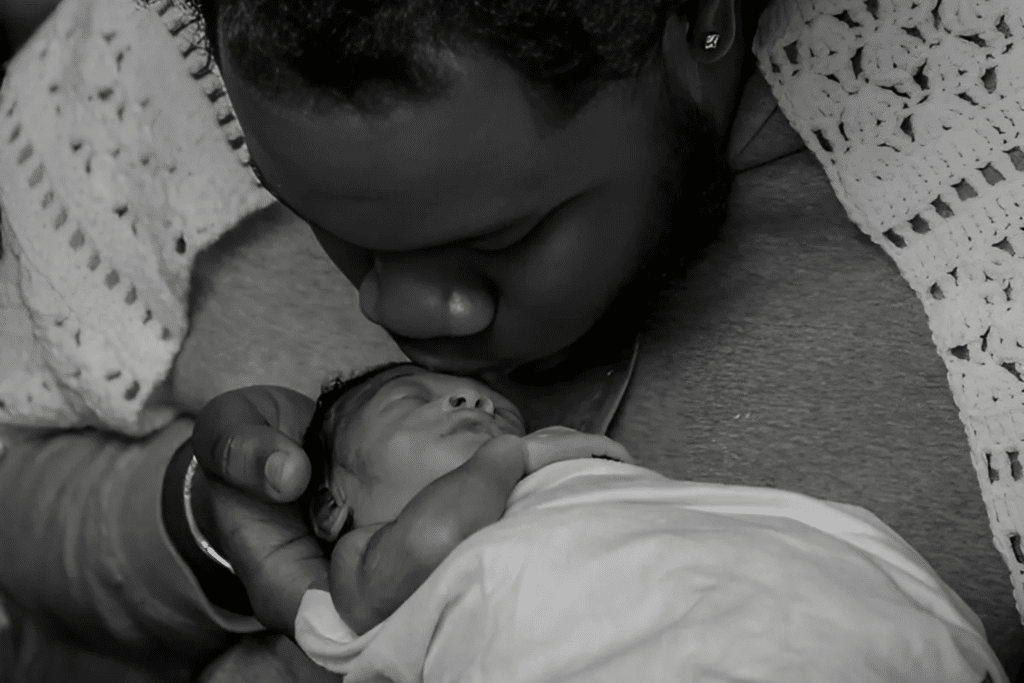 Baby Miracle receives a kiss from Dad