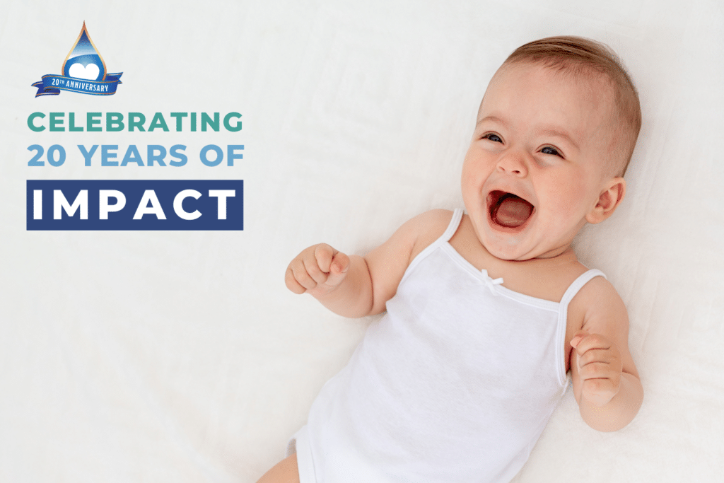 adorable baby girl smiling on white back - celebrating 20 years of impact