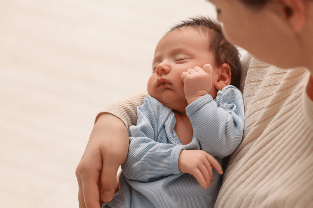 Mother cradles young baby in her arms
